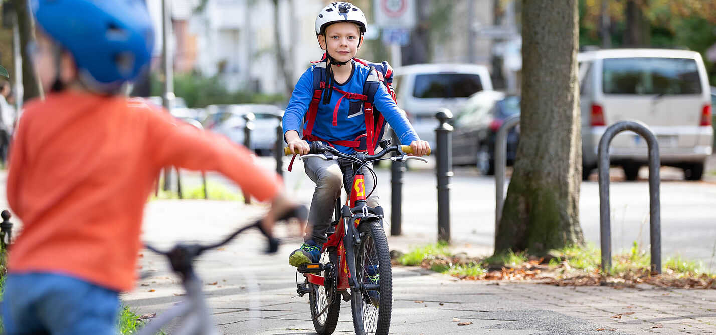 Auf dem Weg zur Schule Ein Kind fährt mit dem Rad zur Schule